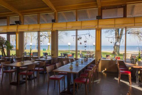 - un restaurant avec des tables et des chaises offrant une vue sur l'océan dans l'établissement Little Tiny Village Haus 2, à Fußach