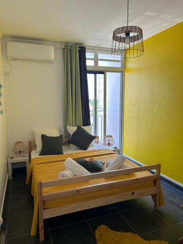 1 dormitorio con cama, sofá y ventana en Appartement avec vue panoramique de Pointe-à-Pitre, en Pointe-à-Pitre