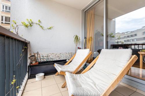 un balcon avec deux chaises et une table dans l'établissement GuestReady - Skyline serenity near famous hotspots, à Paris