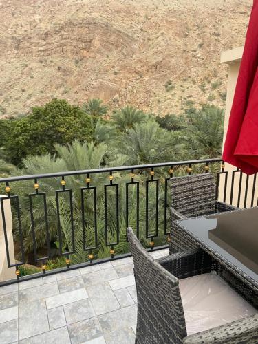 a balcony with a table and chairs overlooking the desert at WADI BANI KALED REST HOUSE in Dawwah