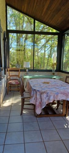 un patio avec une table et des chaises sur un porche dans l'établissement Maison au calme avec vue splendide dans la vallée du Célé, à Sauliac-sur-Célé