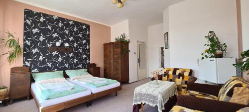 a living room with a bed and a table at Pension Nahořečice in Valeč