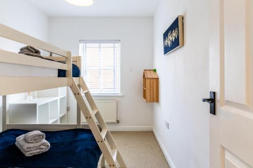a bedroom with a bunk bed and a ladder at Limeslade House in Mumbles - Family & Dog Friendly in The Mumbles
