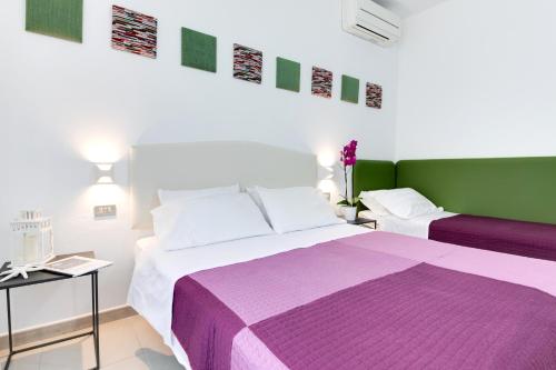 1 dormitorio con 2 camas de color morado y verde en Residence Diffuso Arcobaleno, en Gabicce Mare