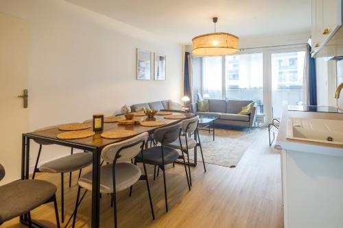 Il comprend une cuisine et un salon avec une table et des chaises. dans l'établissement Grand appartement lumineux au cœur de Thonon, à Thonon-les-Bains