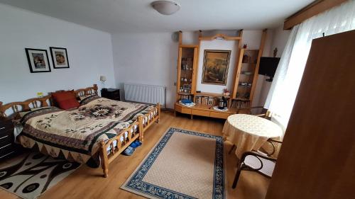 ein Schlafzimmer mit einem Bett und einem Tisch darin in der Unterkunft Vila Zenyt in Piatra Fântânele