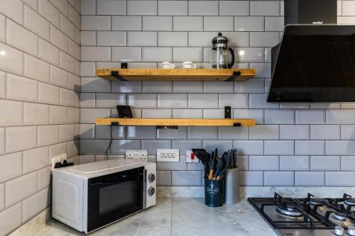a kitchen with a microwave and a stove at Limeslade House in Mumbles - Family & Dog Friendly in The Mumbles