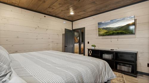 a bedroom with a bed and a tv on the wall at Royce' s Retreat in Sevierville