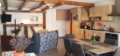 une cuisine et une salle à manger avec une table et des chaises dans l'établissement Corps de ferme traditionnel, à Lembach