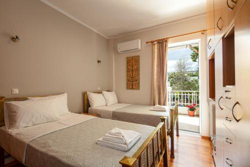 a bedroom with two beds and a balcony at Cozy garden apartment in Rethymno Town