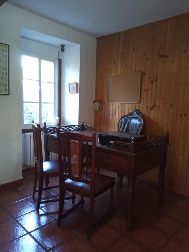 a dining room with a wooden table and chairs at Lar A Rola El precio x una noche es para dia y medio Check in 9am Out 21pm in Sabucedo