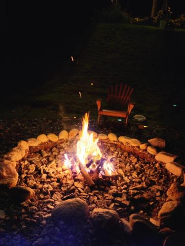 a fire pit with a chair in front of it at Villa Trentino Chalé Pirineus in Teodoros
