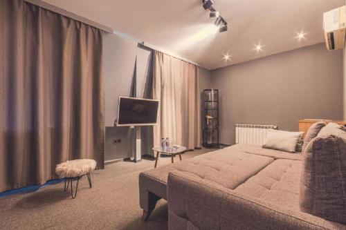 een slaapkamer met een groot bed en een televisie bij Maestro Hotel in Baku