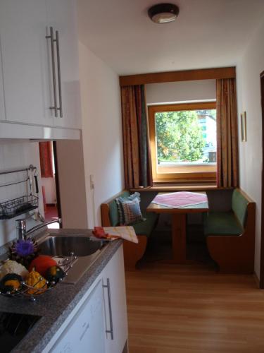 a kitchen with a sink and a table and a window at Appartementhaus Kaltenbach-Stumm by PiaundDirk in Stumm