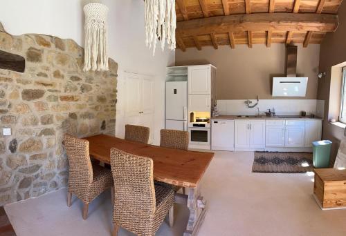 Una cocina con una mesa y sillas de madera. en Mas en Cévennes - Brèç de l'anhel, la Jaça, en Saint-Paul-la-Coste