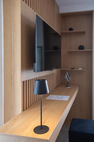 a desk with a lamp and a television on it at Griffin Suites in Heraklio Town