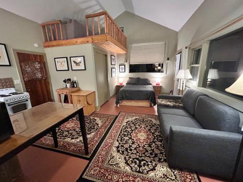 una sala de estar con un sofá y una cama en COZY PEACEFUL WILLOW CREEK CABIN, en Crestone