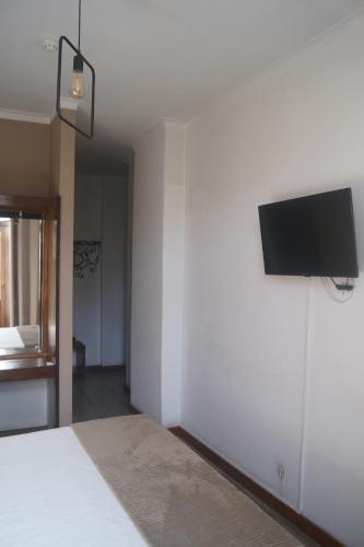 ポルトにあるHotel Chique Aliadosのベッドルーム1室(壁に薄型テレビ付)