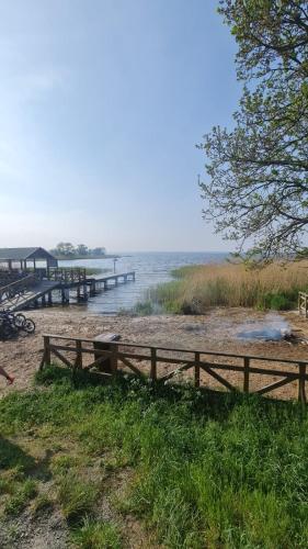 a wooden fence on a beach with a dock at AJP Prestige House Szczecin Załom in Szczecin