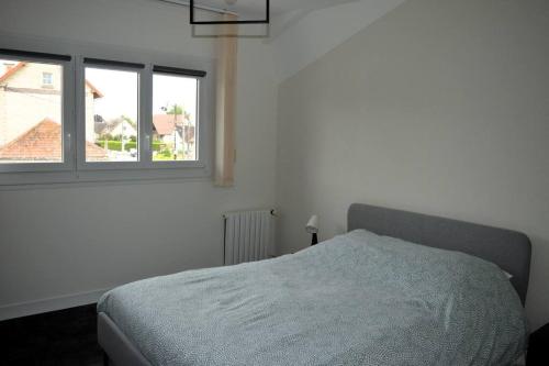 une chambre blanche avec un lit et une fenêtre dans l'établissement Le Dortoir, maison familiale - jardin - 5km mer, à Cresserons