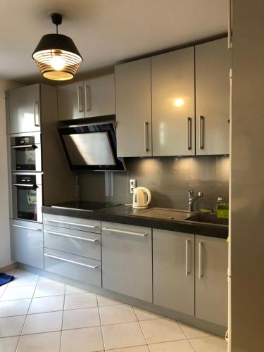 une cuisine avec des armoires blanches et un évier dans l'établissement Idéal T3 top confort Massy Atlantis, à Massy