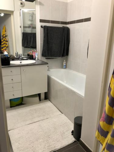 une salle de bain avec une baignoire blanche et un lavabo dans l'établissement Idéal T3 top confort Massy Atlantis, à Massy