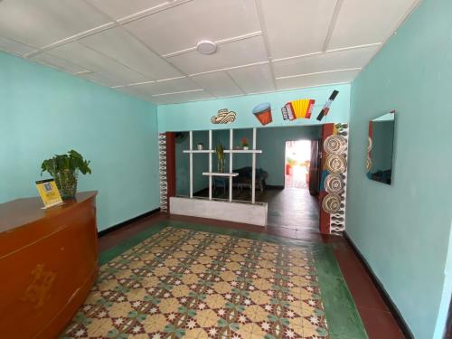 a room with blue walls and a hallway with a table at HOTEL casa VALLENATA in Valledupar