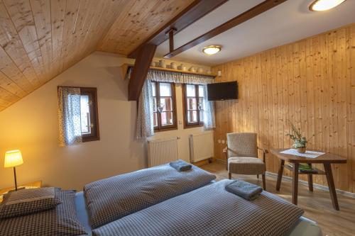 a bedroom with two beds and a table and a tv at Chalupa Maršovka in Horní Maršov