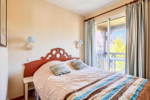 une chambre avec un lit et une grande fenêtre dans l'établissement La Résidence du Golf - maeva Home - Appartement 2 Pièces 5 Personnes - Budget MAE-6644, à Deauville