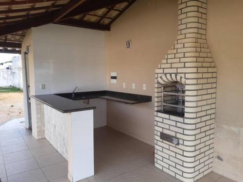 een keuken met een bakstenen oven in een huis bij Casa no Condomínio Parque do Jacuipe com acesso à praia e rio in Barra de Jacuípe