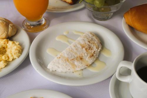eine weiße Platte mit einem Stück Essen auf dem Tisch in der Unterkunft New Casablanca Praia Hotel in Paulista