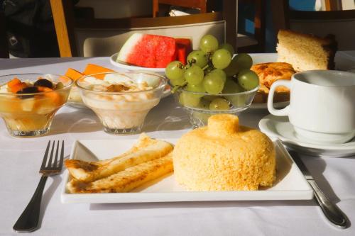 ein Tisch mit einem Teller Essen mit Trauben und Früchten in der Unterkunft New Casablanca Praia Hotel in Paulista