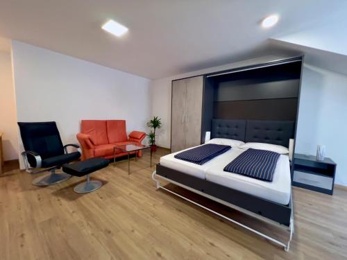 ein Schlafzimmer mit einem großen Bett und zwei Stühlen in der Unterkunft Ferienwohnungen zur POST 2 in Breitenbrunn