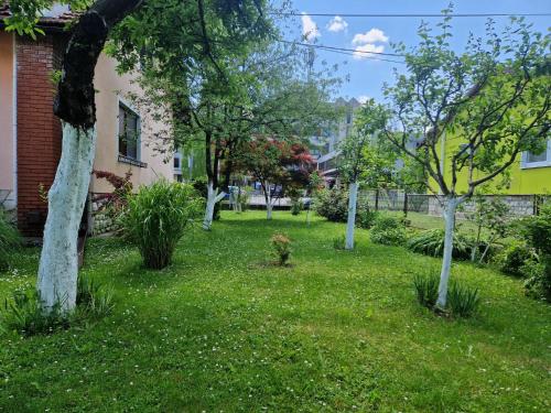 a yard with trees in the grass next to a house at Studio apartman Marica - Ogulin, Hrvatska in Ogulin