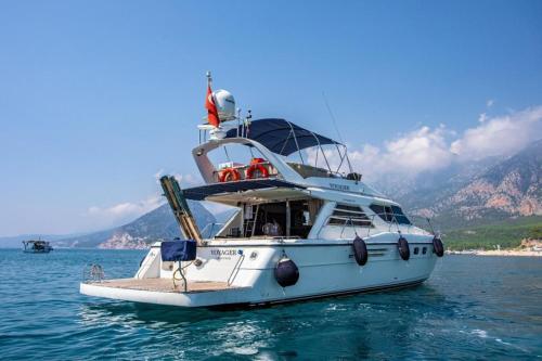 un bote blanco en el agua con montañas en el fondo en luxer holiday, en Antalya