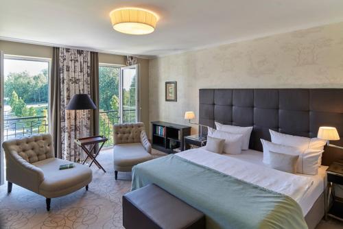 a large bedroom with a large bed and a balcony at Naturresort & Spa Schindelbruch in Stolberg i. Harz