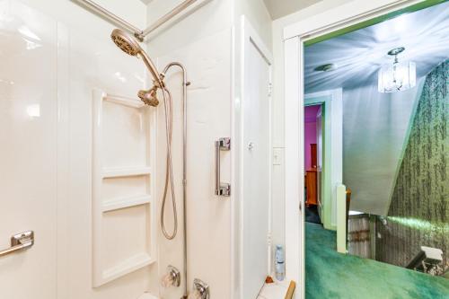 ein Bad mit einer Dusche und einem Spiegel in der Unterkunft Charming West Mifflin House - 3 Mi to Kennywood! in West Mifflin