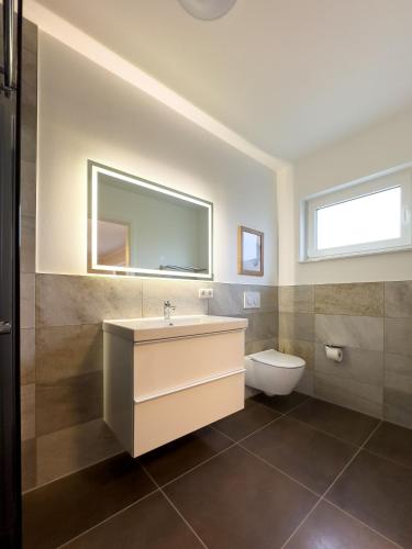 a bathroom with a sink and a toilet at FeWo Rugard in Braunsbedra