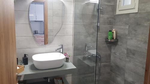 y baño con lavabo y espejo. en Onar View Studio en Néa Péramos