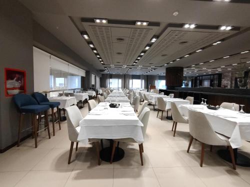a dining room with white tables and chairs at Gran Amérian Carlos V in Termas de Río Hondo