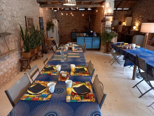 Eine Gruppe von Tischen in einem Raum mit blauen Tischdecken in der Unterkunft La Grange de Lucie -chambres d'hôtes en Périgord-Dordogne in Nanteuil-de-Bourzac