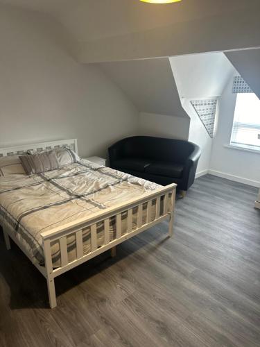 a bedroom with a bed and a black chair at Apartment 2 Sheriff suits in Hartlepool