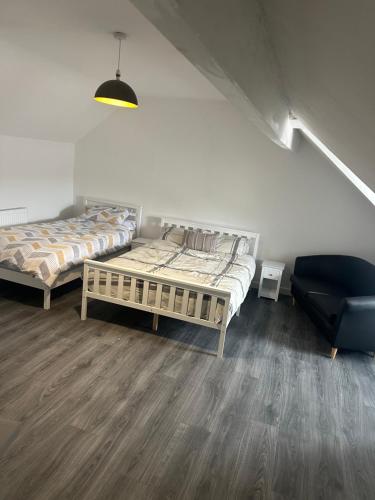 a room with two beds and a chair in it at Apartment 2 Sheriff suits in Hartlepool