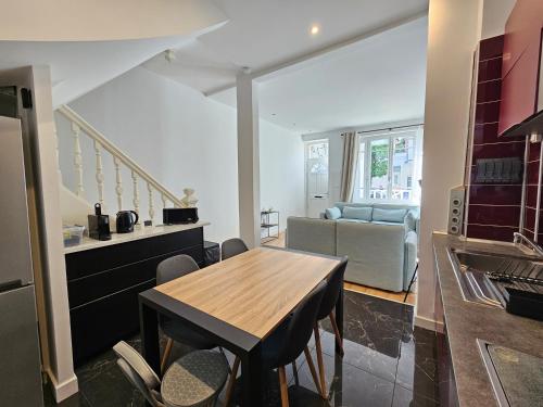 une cuisine et un salon avec une table et un canapé dans l'établissement Maison plein centre de Deauville, à Deauville