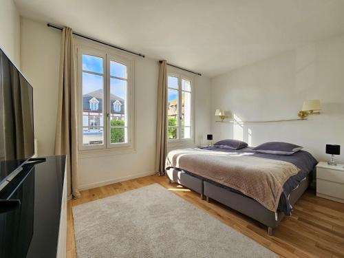 um quarto com uma cama e uma grande janela em DEAUVILLE Maison plein centre, ideale famille ! em Deauville