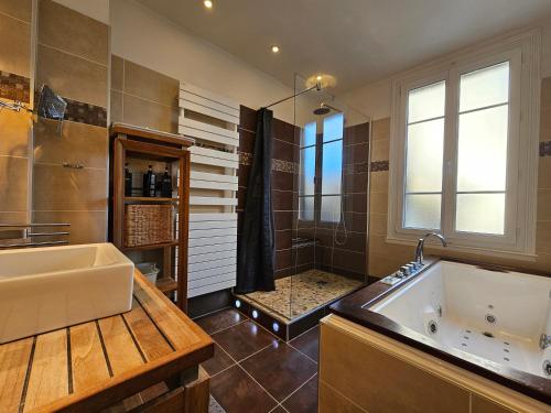 une grande salle de bain avec baignoire et douche dans l'établissement Maison plein centre de Deauville, à Deauville