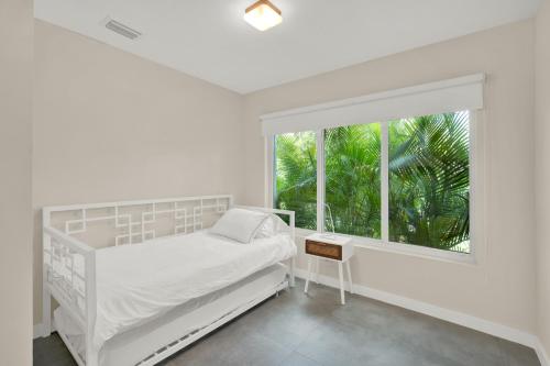 a white bedroom with a bed and a window at Stunning Home LifeStyle Miami in Miami