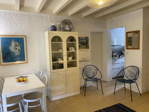 una cocina con una cabaña blanca, una mesa y sillas en Lou Galip, en Cap-Ferret