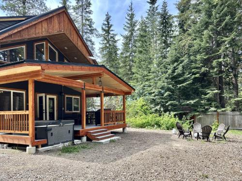 a log cabin with a porch and chairs in a yard at Compass Cabin by NW Comfy Cabins in Leavenworth