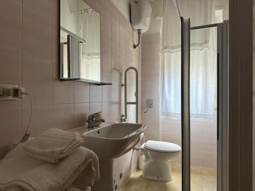 een witte badkamer met een wastafel en een toilet bij Peschici a due passi in Peschici